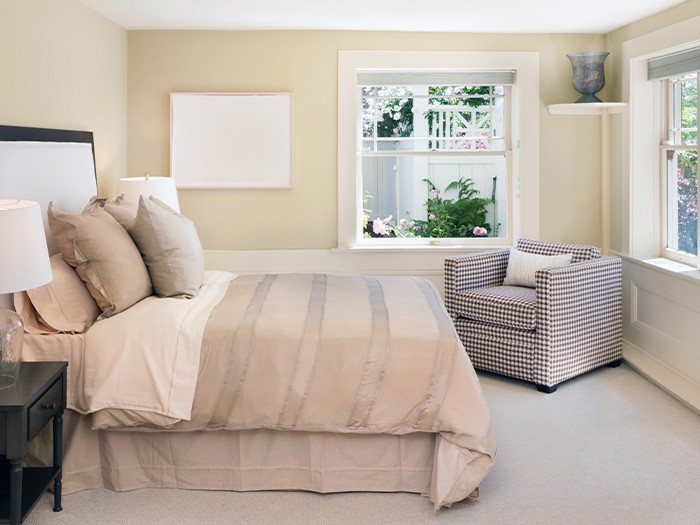 Brightly painted bedroom with bed and accent chair.